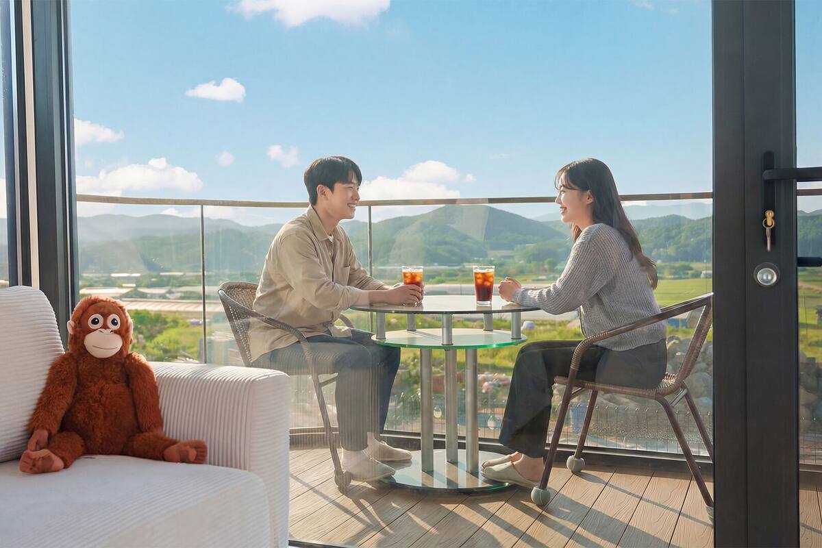 A couple dining at a table with a view of a mountainous landscape.