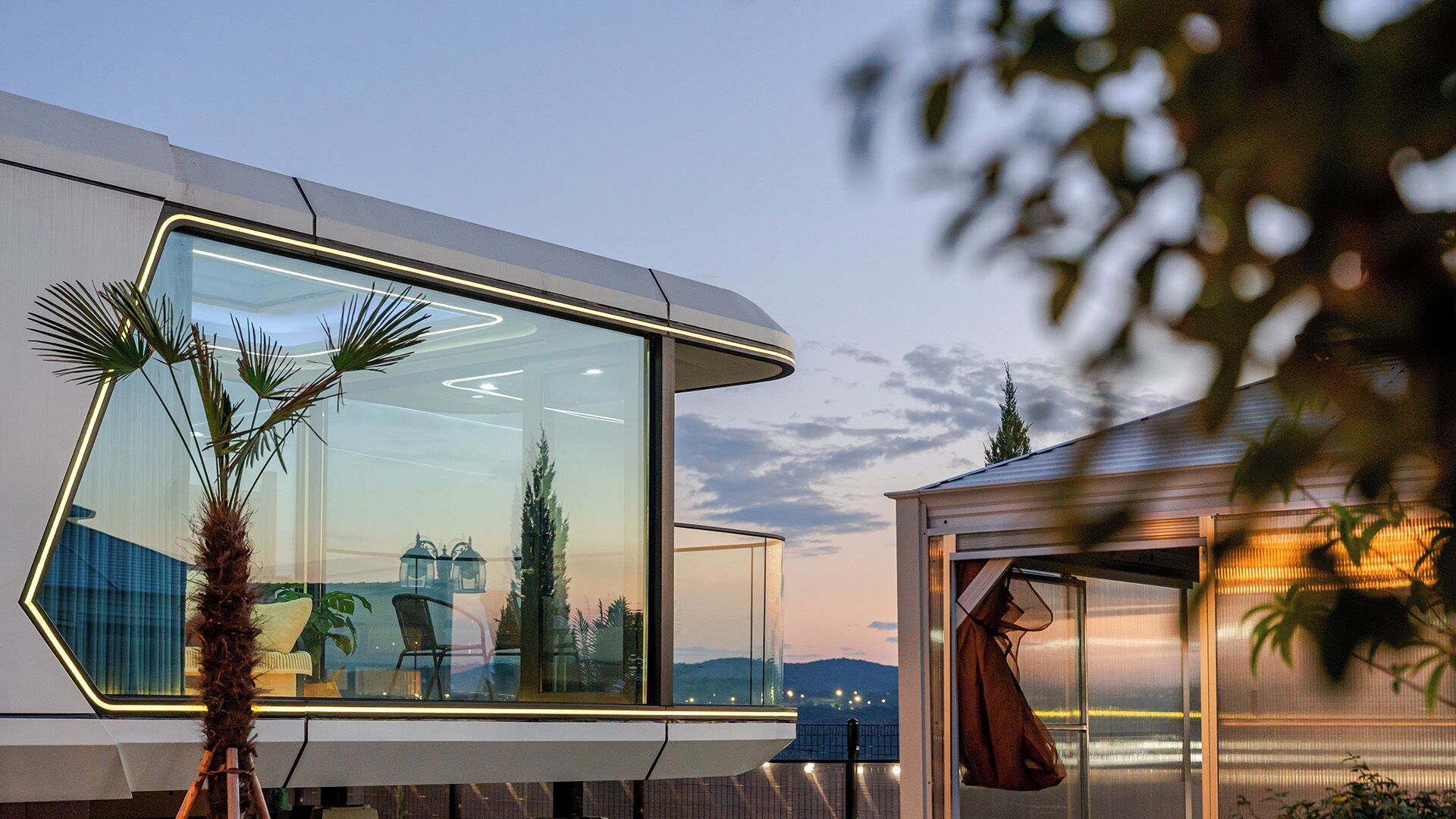 Un edificio moderno con amplios ventanales, techo plano y vistas al paisaje.