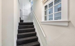 Eine Treppe mit dunkel bezogenen Stufen, die zu einer Zwischenebene führt.