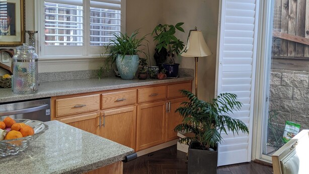 A kitchen with wooden cabinets, a granite countertop, a built-in oven, and a window with blinds. - Executive home close to Keller Beach & Point Pinol shoreline extended stay (Richmond)