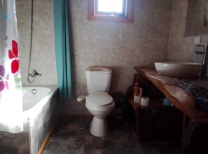 Un bagno con vasca, water e lavandino.