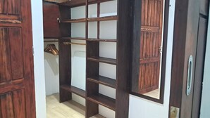 A room with a wooden wardrobe, a white door, and a wooden floor. - Katara Gili Boutique Rooms and Bungalows (Gili Trawangan)