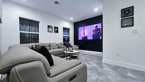 A modern living room with a sectional sofa, a flat-screen TV, and a small coffee table.