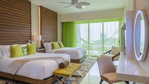 Ein Hotelzimmer mit zwei Betten, einer Sitzecke, einem Fernseher und einem Balkon mit grünen Vorhängen.