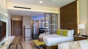 Ein Hotelzimmer mit Bett, Nachttisch, Sessel und Schreibtisch mit Stuhl.
