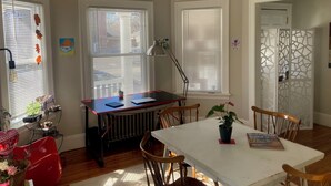 A dining area with a table, chairs, a radiator, and a window with blinds. - The perfect blend of space and comfort in Providence, RI. (Providence)