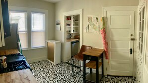A compact kitchen with a gas stove, a dishwasher, and a small dining area with a chair and table. - The perfect blend of space and comfort in Providence, RI. (Providence)
