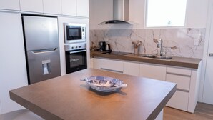Una cocina moderna con una isla central, electrodomésticos de acero inoxidable y un salpicadero de mármol.