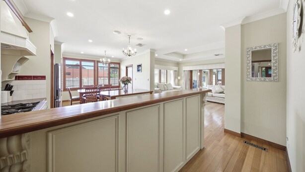 A spacious kitchen with a central island, a dining area with a wooden table, and a living room with a sofa. - Huge Clyde Holiday Propery: 2 Houses/Bar/BBQ/Pool (Clyde)