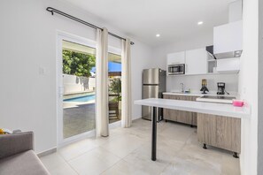 Eine moderne Küche mit eingebauter Mikrowelle, einem Edelstahl-Kühlschrank und einer weißen Arbeitsplatte.