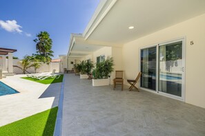 Eine moderne Außenpatio mit Pool, Liegestühlen und Topfpflanzen.