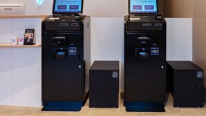 Two self-service kiosks with screens displaying the 'toyoko inn' logo, a printer, and a recycling bin. - Toyoko Inn Kure-eki (Kure)
