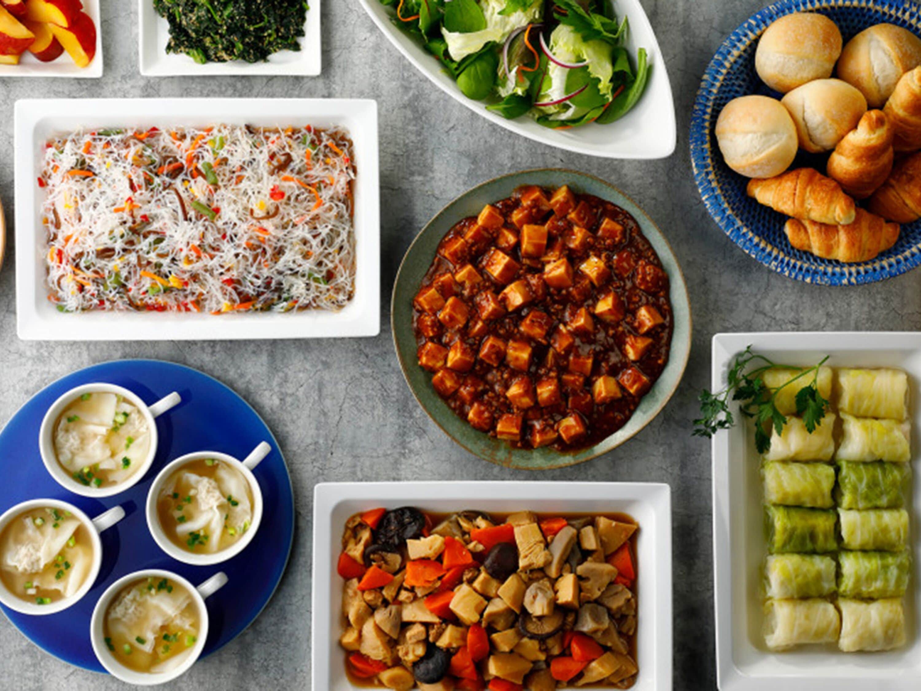 A variety of dishes including a noodle salad, tofu stew, and dumplings.
