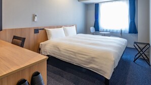 A hotel room with a bed, a desk, a chair, a small table, and a window with curtains. - Toyoko Inn Kure-eki (Kure)