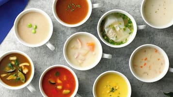 Nine bowls of soup arranged on a table.