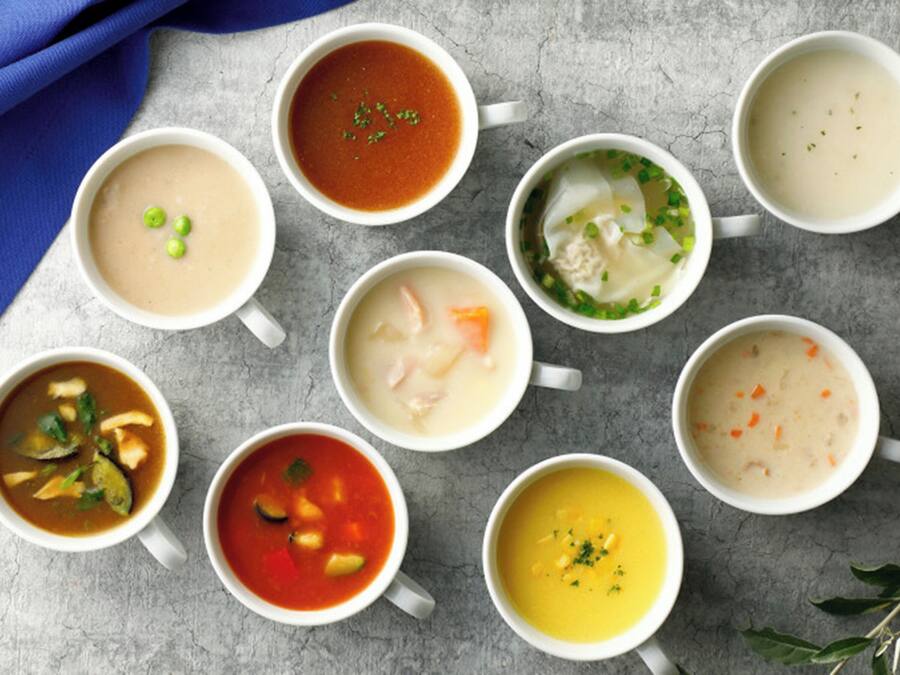 Nine bowls of soup arranged on a table.