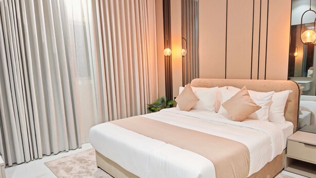 A modern bedroom with a large bed, a bedside table, a nightstand, and a mirror. - Fantastic 1-bedroom apartment with AC in vibrant Jeddah (Jeddah)