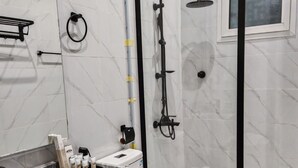 A modern bathroom with a marble vanity, a glass shower enclosure, and a toilet. - Fantastic 1-bedroom apartment with AC in vibrant Jeddah (Jeddah)