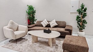 A modern living room with a sofa, armchair, ottoman, and coffee table. - Fantastic 1-bedroom apartment with AC in vibrant Jeddah (Jeddah)