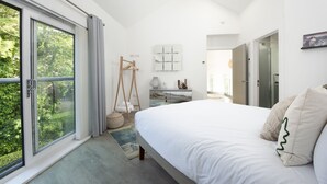 A bedroom with a large bed, a desk, a chair, and a wardrobe. - Estuary Watch - River view, Pets welcome, Family Friendly (Lelant)