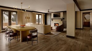 A modern living room with a fireplace, a large window, and a bar area. - Ski-in/Ski-out Park Hyatt Beaver Creek | Luxury Double Villa (Avon)