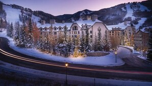 A large resort with multiple buildings, a snow-covered landscape, and a road with light trails. - Ski-in/Ski-out Park Hyatt Beaver Creek | Luxury Double Villa (Avon)