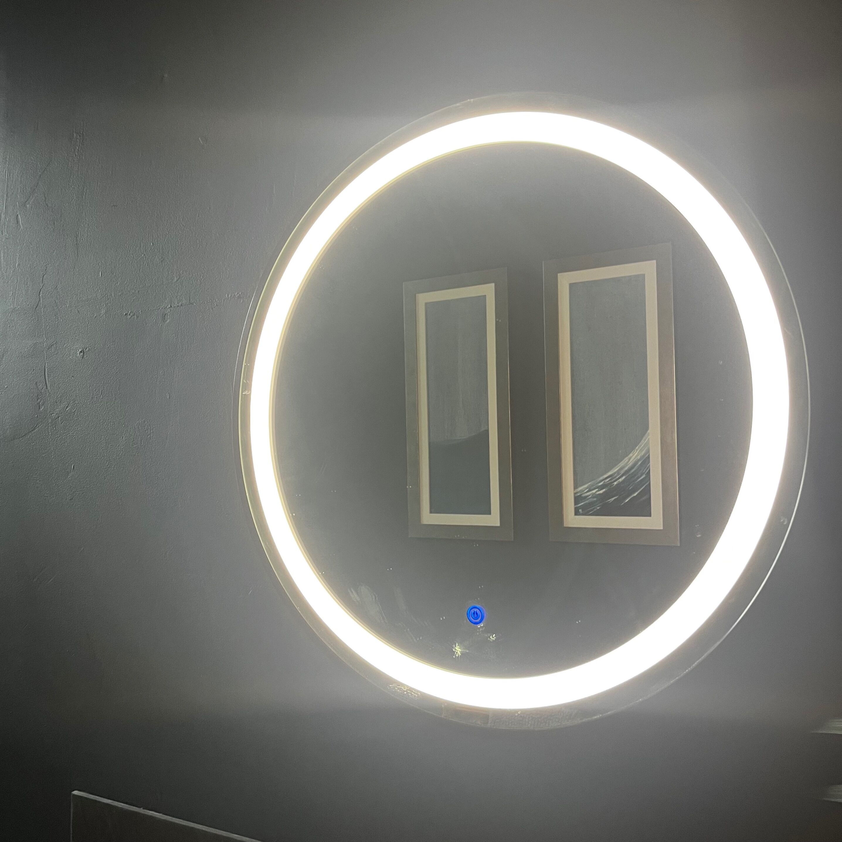 A circular light fixture with a blue switch on a dark wall.