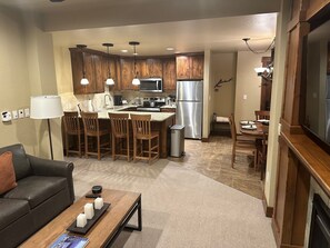 Una cocina moderna con armarios de madera, electrodomésticos de acero inoxidable y un comedor con mesa y sillas.