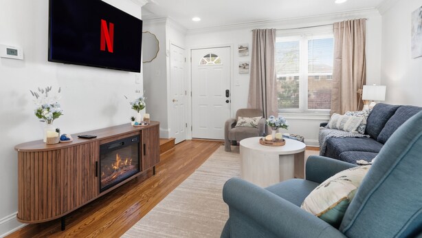 A living room with a flat-screen TV, a fireplace, a sofa, and a coffee table. - Stylish 3-bedroom Escape in charming Alexandria 5 Min to Old Town, Metro Nearby (Alexandria)