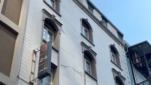 A multi-story building with a sign indicating '24 INN' and a visible window with a curtain. - 24 Inn at BTS Phrom Phong (Bangkok)