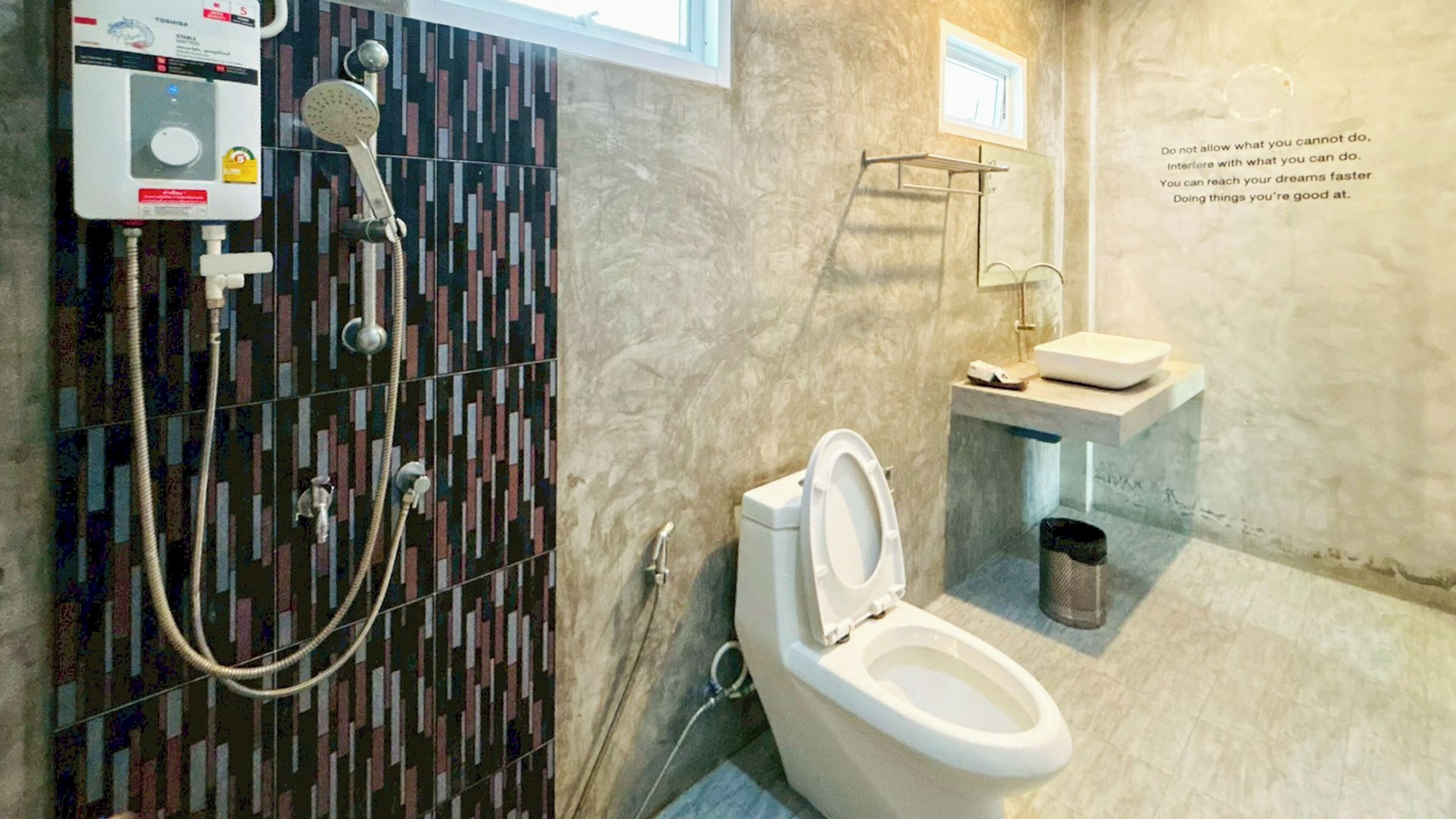 Un baño de diseño moderno, que incluye inodoro, lavabo y zona de ducha con panel de control.
