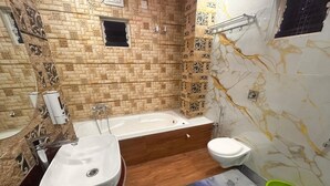A bathroom with a bathtub, a sink, and a toilet. - Hotel Runway (Barakpur)