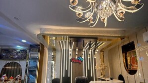 A reception area with a modern chandelier, a reception desk, and a neon sign. - Hotel Runway (Barakpur)