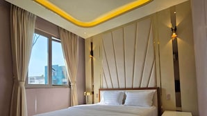 A modern hotel room with a large bed, a nightstand, and a window with curtains. - li qiong hotel (Ho Chi Minh City)