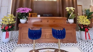 A hotel reception desk with a chandelier, a sign reading 'LE QUINH HOTEL,' and decorative plants. - li qiong hotel (Ho Chi Minh City)