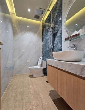 Deluxe tweepersoonskamer | Badkamer | Een douche, een regendouche, een haardroger, badjassen