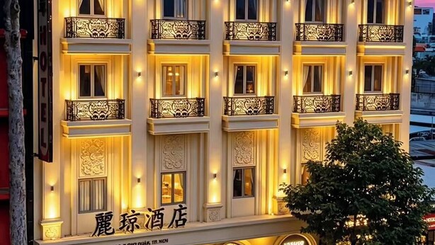 A multi-story hotel with balconies, a ground-level retail space, and a sign indicating a hotel name. - li qiong hotel (Ho Chi Minh City)