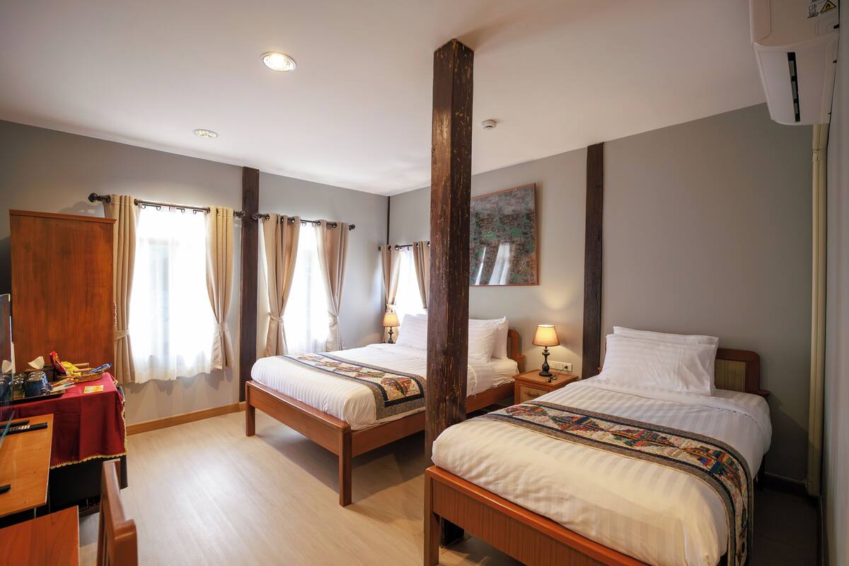 Une chambre d’hôtel avec deux lits, un bureau et une armoire.