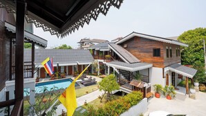 Une propriété résidentielle dotée d’une piscine, de plusieurs balcons et d’un patio couvert.