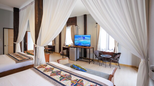 Une chambre d’hôtel équipée d’un lit, d’une télévision, d’un bureau et d’une chaise.