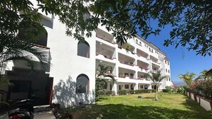 A multi-story building with balconies, a paved driveway, and a well-maintained lawn. - Beautiful & Spacious 2 bed 2 bath Condo in Casa Bonita.  Ixtapa ,Zihuatanejo (Ixtapa Zihuatanejo)
