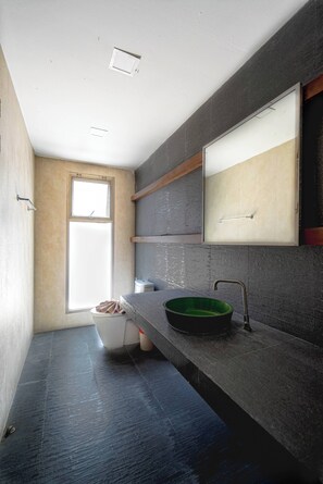 Ein modernes Badezimmer mit einem großen Fenster, einem grünen Waschbecken und einem Spiegel darüber.