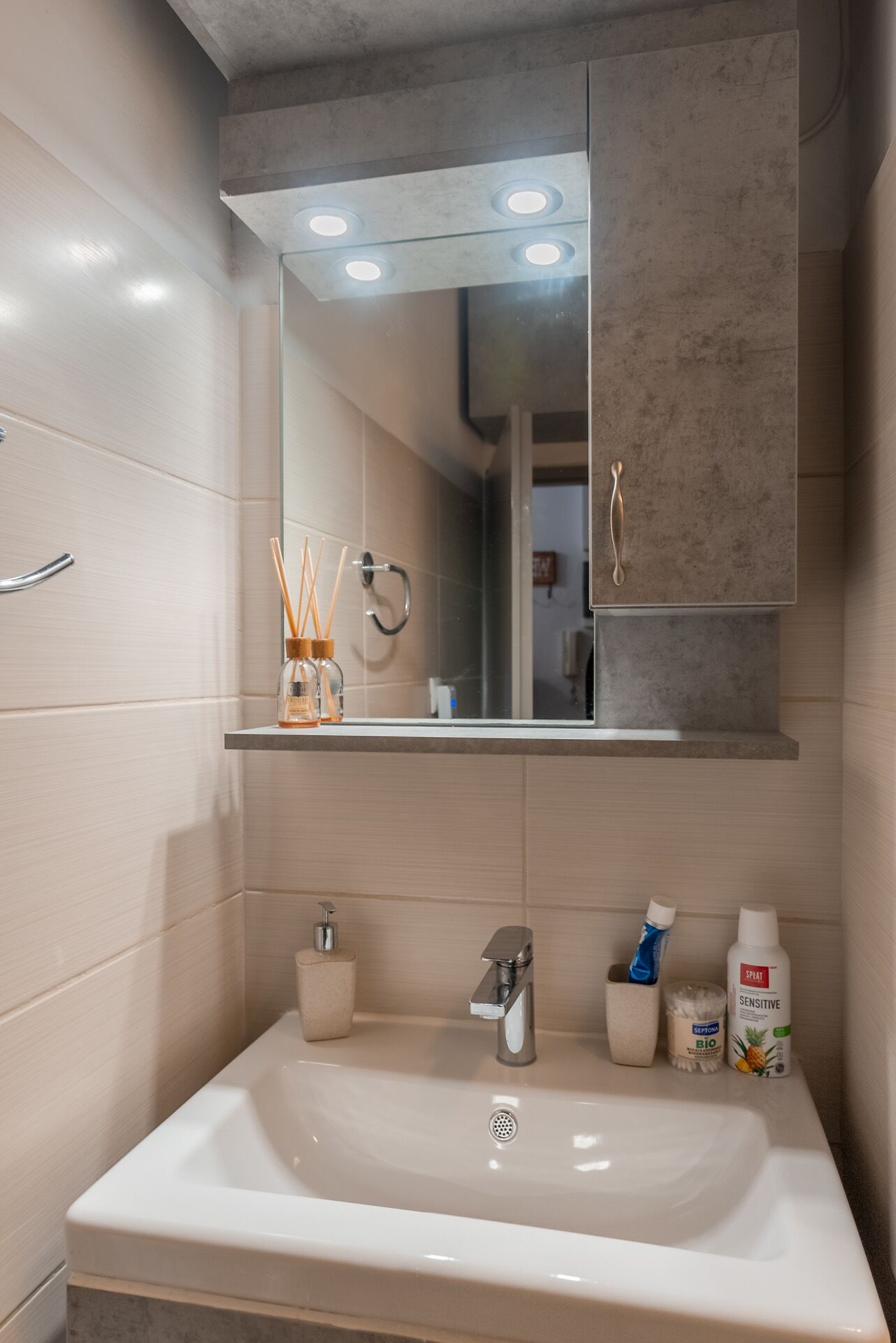 Un baño moderno con un lavamanos grande, espejo y mueble de almacenamiento.