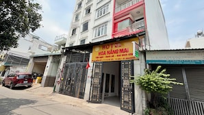 A multi-story building with a prominent yellow sign for a hotel. - Hoa Nang Mai Hotel (Ho Chi Minh City)