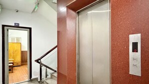 An elevator, a staircase with metal railings, and a door marked with the number 203. - Hoa Nang Mai Hotel (Ho Chi Minh City)