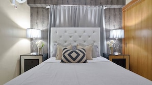 A bedroom with a tufted headboard, two bedside tables with lamps, and a bed with patterned bedding. - Luxurious 3-bedroom Condo With City Views in Santo Domingo (Santo Domingo)