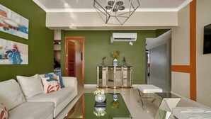 A modern living room with a sofa, coffee table, and a decorative mirror. - Luxurious 3-bedroom Condo With City Views in Santo Domingo (Santo Domingo)