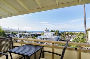 Uma varanda com vista para a área costeira, incluindo edifícios e uma torre.