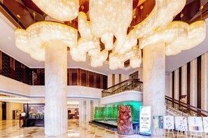 A spacious lobby with a grand chandelier, marble columns, and a staircase. - The Royal International Hotel (Ordos)