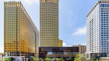 A hotel with multiple high-rise buildings, a parking lot, and a clear sky.